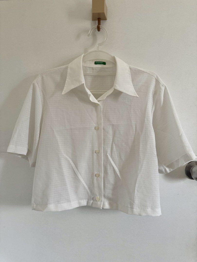White Cropped Short Sleeve Button-Down Top (Category: Blouses) located in Marikina City. Submitted by hellolei_c (Listing ID 1452810690, Image 1). Description: Brand: United Colors of Benetton Color: White Style: Cropped / Boxy / Casual Polo / Lightweight / Minimalist Size: Medium Fabric/Texture: Lightweight, breathable, semi-sheer weave Sleeve Length: Short sleeves Features: Pointed collar, full front button closure.