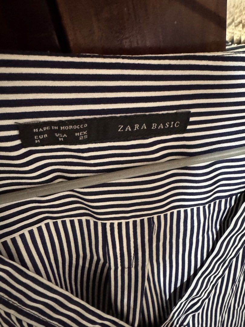 Zara Basic Striped V-Neck Blouse with Gold Shoulder Detail (Category: Blouses) located in Marikina City. Submitted by 1stuffshop (Listing ID 1452725260, Image 2). Description: - Zara Basic navy and white striped blouse - V-neckline with subtle gold shoulder detail - Three-quarter sleeves with a rolled-up effect - Relaxed fit with side slits - Versatile for casual outings or office wear Need to declutter clothes that are not my size anymore..