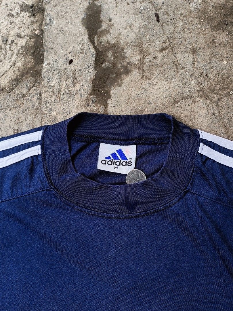 Adidas 90s Vintage Shirt (Category: Tshirts & Polo Shirts ) located in Cavite. Submitted by akyyyy (Listing ID 1452894820, Image 3). Description: vintage 1990s blue Adidas t-shirt featuring classic white three-stripes on the sleeves and a small logo patch on the chest. Width: 21 Length: 30/32 Happy Shopping 🛍️😄.