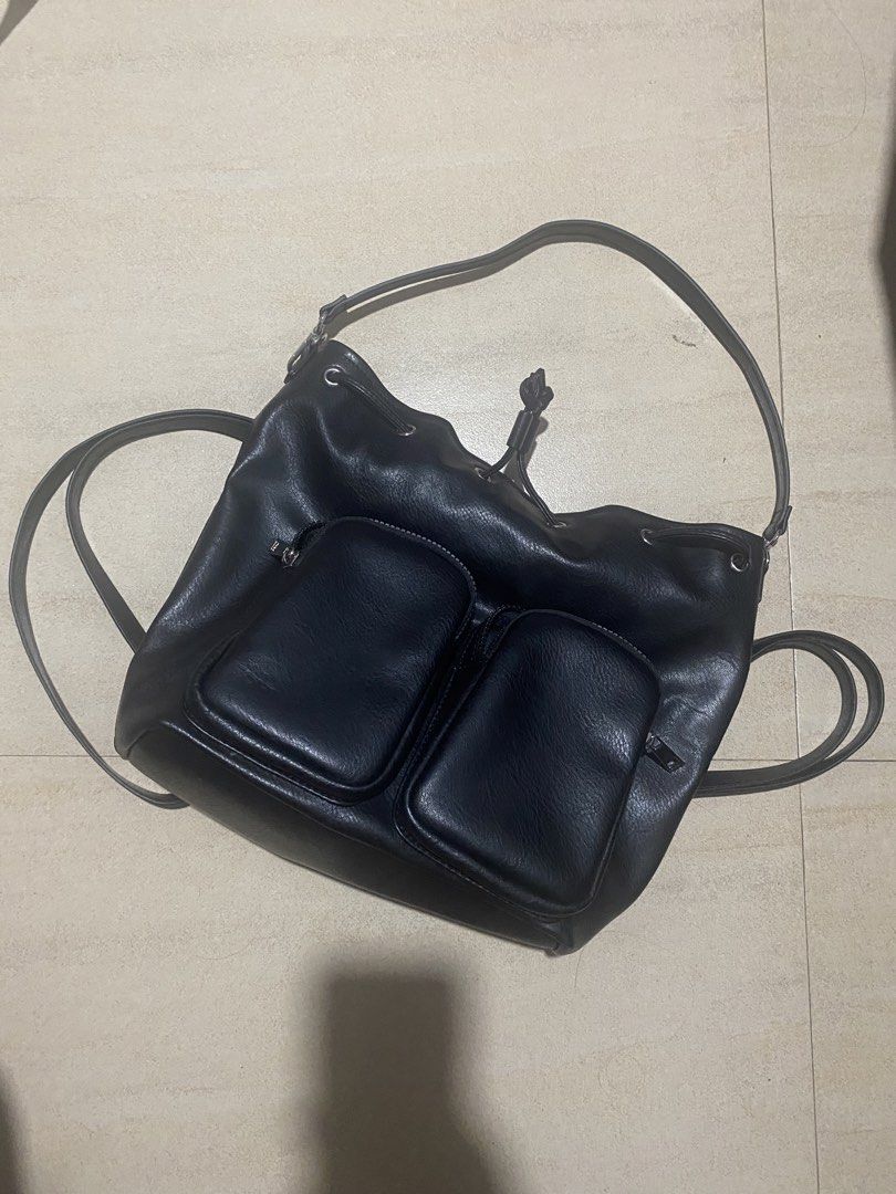 Black Faux Leather Drawstring Bucket Bag with Front Pockets (Category: Shoulder Bags) located in Manila. Submitted by _andireya (Listing ID 1452881740, Image 1). Description: - Stylish black faux leather backpack - Secure drawstring closure at the top - Two convenient front pockets with button closures - Adjustable shoulder straps for a custom fit - Spacious interior to carry your everyday essentials - Ideal for daily use and on-the-go.
