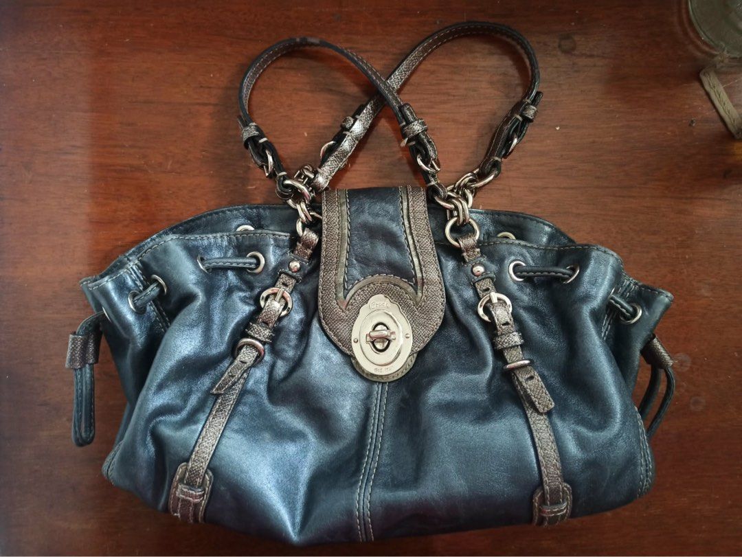 Coach Legacy Vintage Leather Drawstring Handbag (Category: Luxury Bags & Wallets) located in Quezon City. Submitted by aparador_finds (Listing ID 1452944279, Image 2). Description: - well loved - Authentic dark blue Coach leather handbag - Secure drawstring closure with a turn-lock clasp - Luxurious satin interior lining - Shows some signs of wear on leather and hardware, adding character.