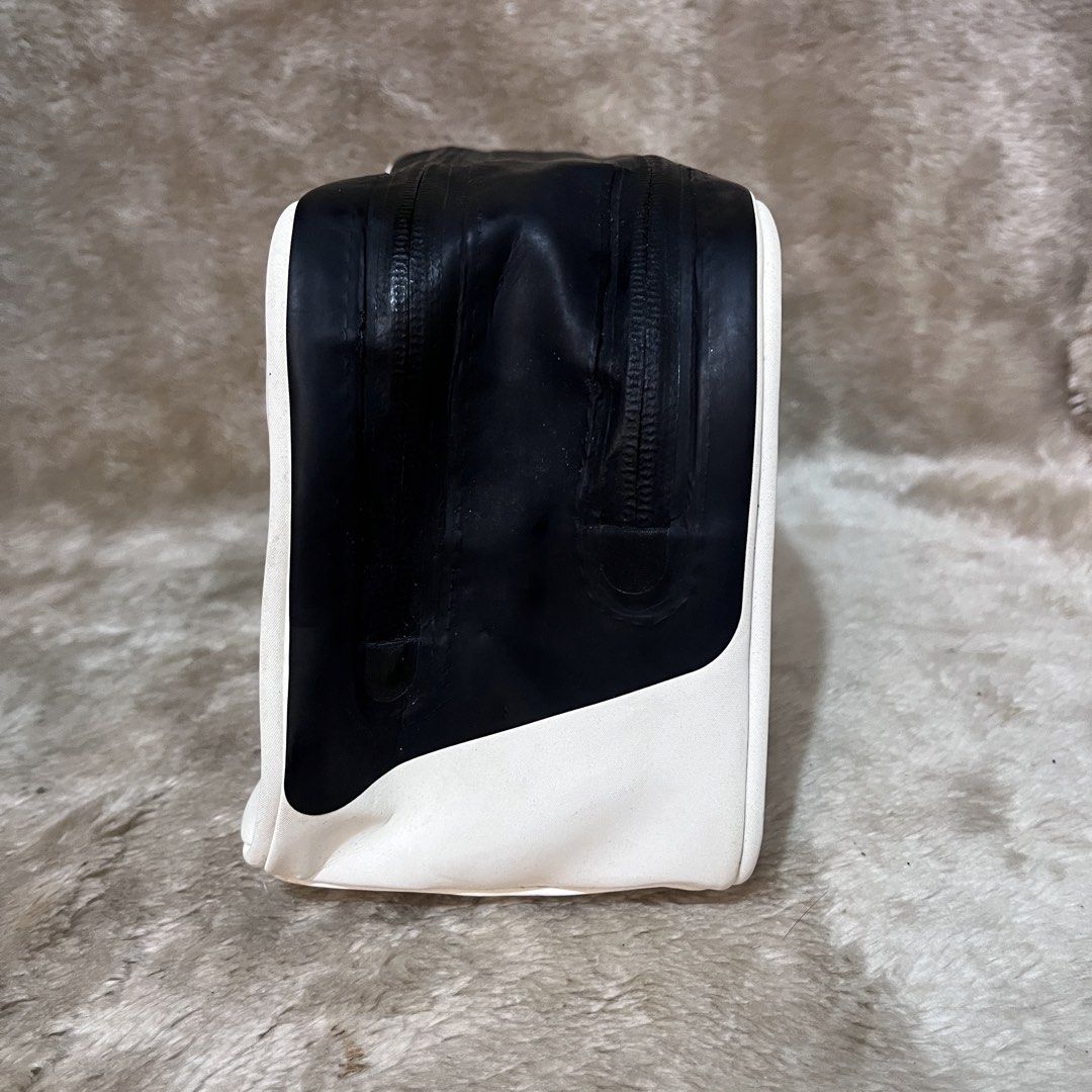 Fitleist Golf Pouch Bag Black White (Category: Golf) located in Cabadbaran. Submitted by dfgthriftology (Listing ID 1452983881, Image 2). Description: - Titleist pouch bag in black and white. - Main compartment with an internal zip pocket. - Zippers are smooth and functional. - Minor exterior marks and scuffs from normal use. - Side handle is intact and secure. - Ideal for storing golf accessories or toiletries..