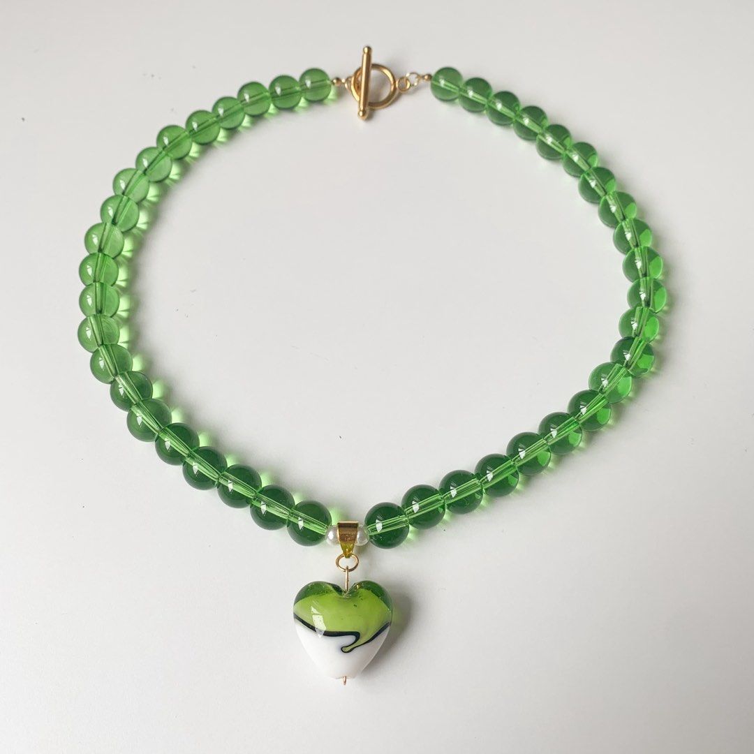Green Beaded Necklace with Heart Charm (Category: Necklaces) located in Marikina City. Submitted by aimamor (Listing ID 1452957806, Image 3). Description: - Adorable green beaded necklace - Features a charming heart-shaped pendant with green and white details - Secure toggle clasp closure - Perfect for adding a vibrant touch to any look - Versatile for both casual and dressed-up occasions.