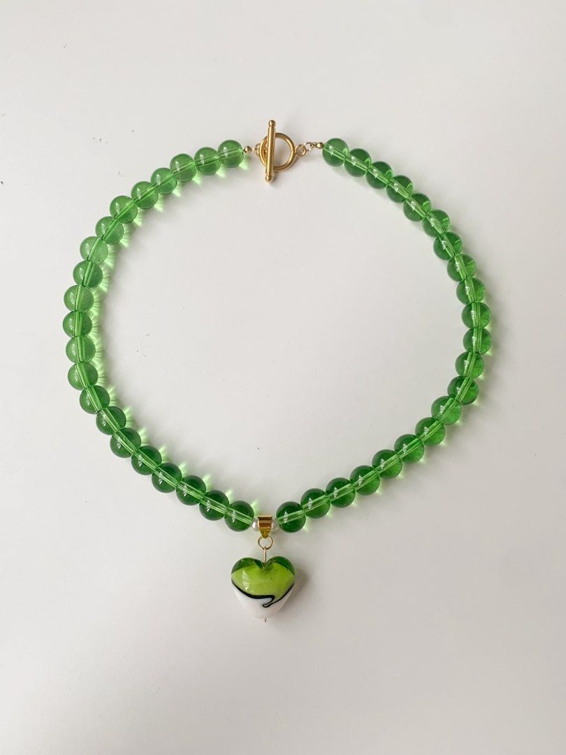 Green Beaded Necklace with Heart Charm (Category: Necklaces) located in Marikina City. Submitted by aimamor (Listing ID 1452957806, Image 2). Description: - Adorable green beaded necklace - Features a charming heart-shaped pendant with green and white details - Secure toggle clasp closure - Perfect for adding a vibrant touch to any look - Versatile for both casual and dressed-up occasions.