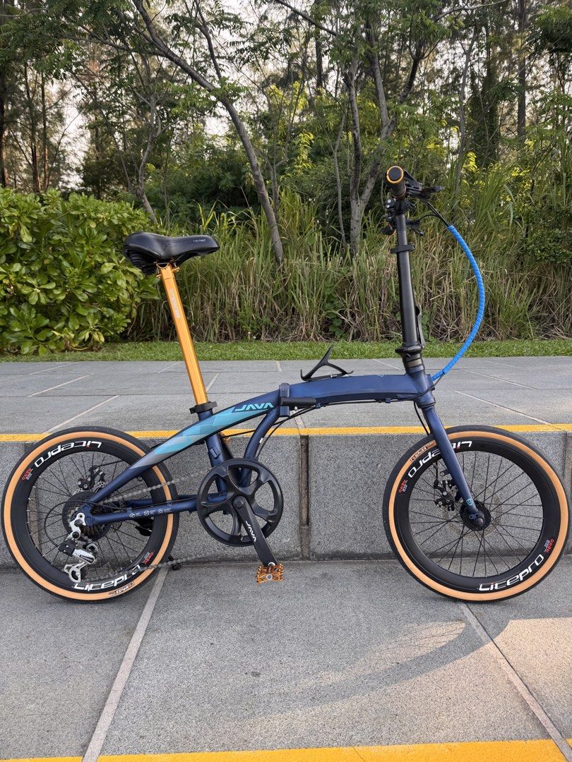Java Foldable Bike (Category: Bicycles) located in Singapore. Submitted by justtrying.penguin (Listing ID 1452881047, Image 1). Description: - Java Foldable Bike - Stylish deep blue frame with gradient details - Tan tires for a unique look - Folds for easy storage and transport - Convenient for urban commuting - 20inch wheels and shimano 7 speed.