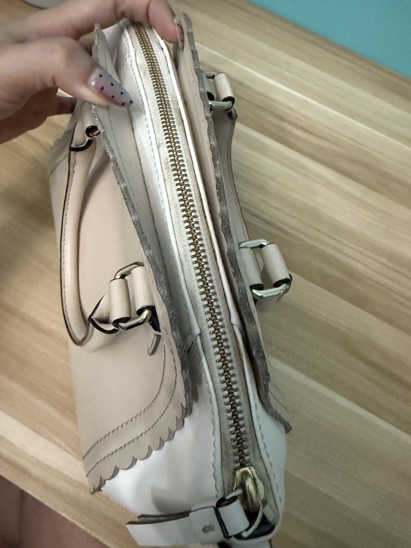 Kate Spade Scallop Trim Leather Handbag (Category: Luxury Bags & Wallets) located in Paranaque City. Submitted by prelovedbyysa (Listing ID 1452946572, Image 3). Description: - Authentic Kate Spade handbag - Color: Cream and white leather - Design: Scalloped edge detail - Features: Top handles, zip closure, metal feet on bottom - No more long strap and dust bag - Has stains inside please see pictures - Still smooth exterior .