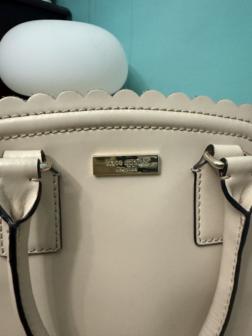 Kate Spade Scallop Trim Leather Handbag (Category: Luxury Bags & Wallets) located in Paranaque City. Submitted by prelovedbyysa (Listing ID 1452946572, Image 2). Description: - Authentic Kate Spade handbag - Color: Cream and white leather - Design: Scalloped edge detail - Features: Top handles, zip closure, metal feet on bottom - No more long strap and dust bag - Has stains inside please see pictures - Still smooth exterior .