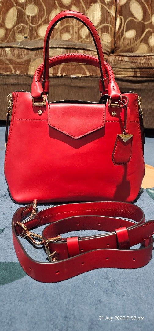 Michael Kors Red Leather Satchel Handbag (Category: Luxury Bags & Wallets) located in Baguio. Submitted by msgold2601 (Listing ID 1453048886, Image 3). Description: - Authentic Michael Kors red leather satchel - Elegant gold hardware details - Includes a detachable shoulder strap for versatile carrying - Secure top zip closure - Stylish braided top handles - Ample interior space for your essentials - Ideal for both everyday use and evening outing