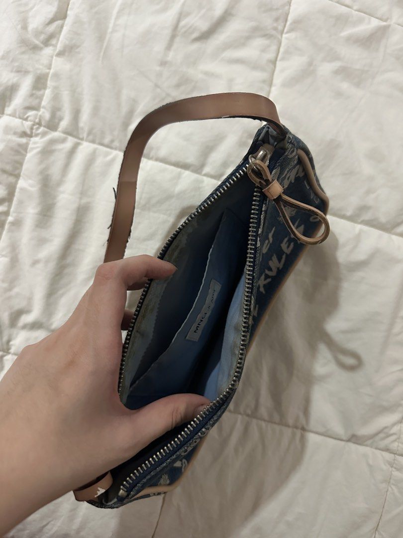 MNG Jeans Denim Graffiti Shoulder Bag (Category: Shoulder Bags) located in Manila. Submitted by jiggaboo6767 (Listing ID 1453033472, Image 2). Description: - Cute MNG Jeans denim shoulder bag - Features a cool graffiti print - Tan leather strap and trim - Secure zipper closure - Includes an inner pocket - Ideal for everyday wear.