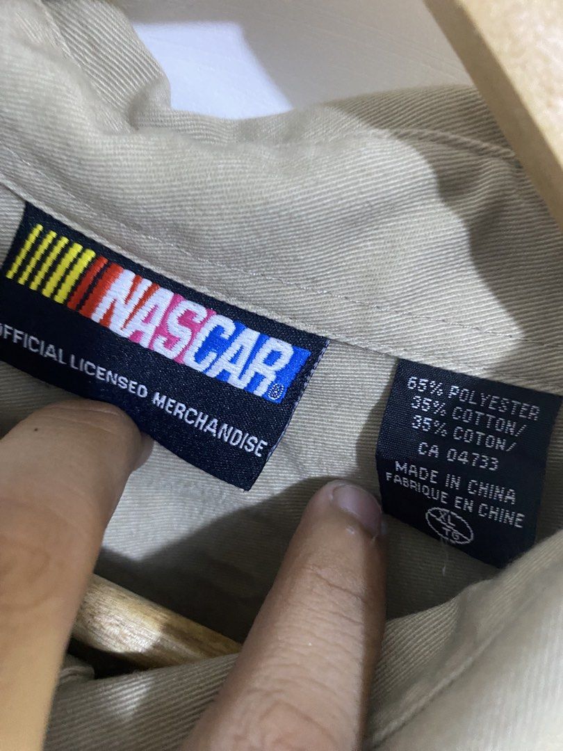 NASCAR Racing Jacket - Official Licensed Merchandise (Category: Coats, Jackets and Outerwear) located in Calamba. Submitted by curlybang (Listing ID 1452900091, Image 3). Description: - Cool tan NASCAR Racing jacket - Official NASCAR logo on the front - Large graphic design on the back - Made from a comfortable polyester and cotton blend - Features a secure snap button closure - Two convenient chest pockets - Ideal for any racing enthusiast.
