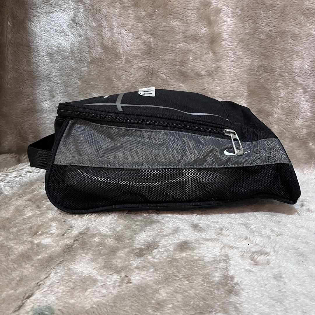 Nike Golf Shoe Bag Black (Category: Golf) located in Butuan. Submitted by dfgthriftology2.0 (Listing ID 1452938064, Image 2). Description: - Nike Golf Shoe Bag - Color: Black with Grey accents - Top handle for easy carrying - Zippered main compartment - Mesh side panels for ventilation - Interior mesh pockets - Ideal for keeping golf shoes clean and organized.