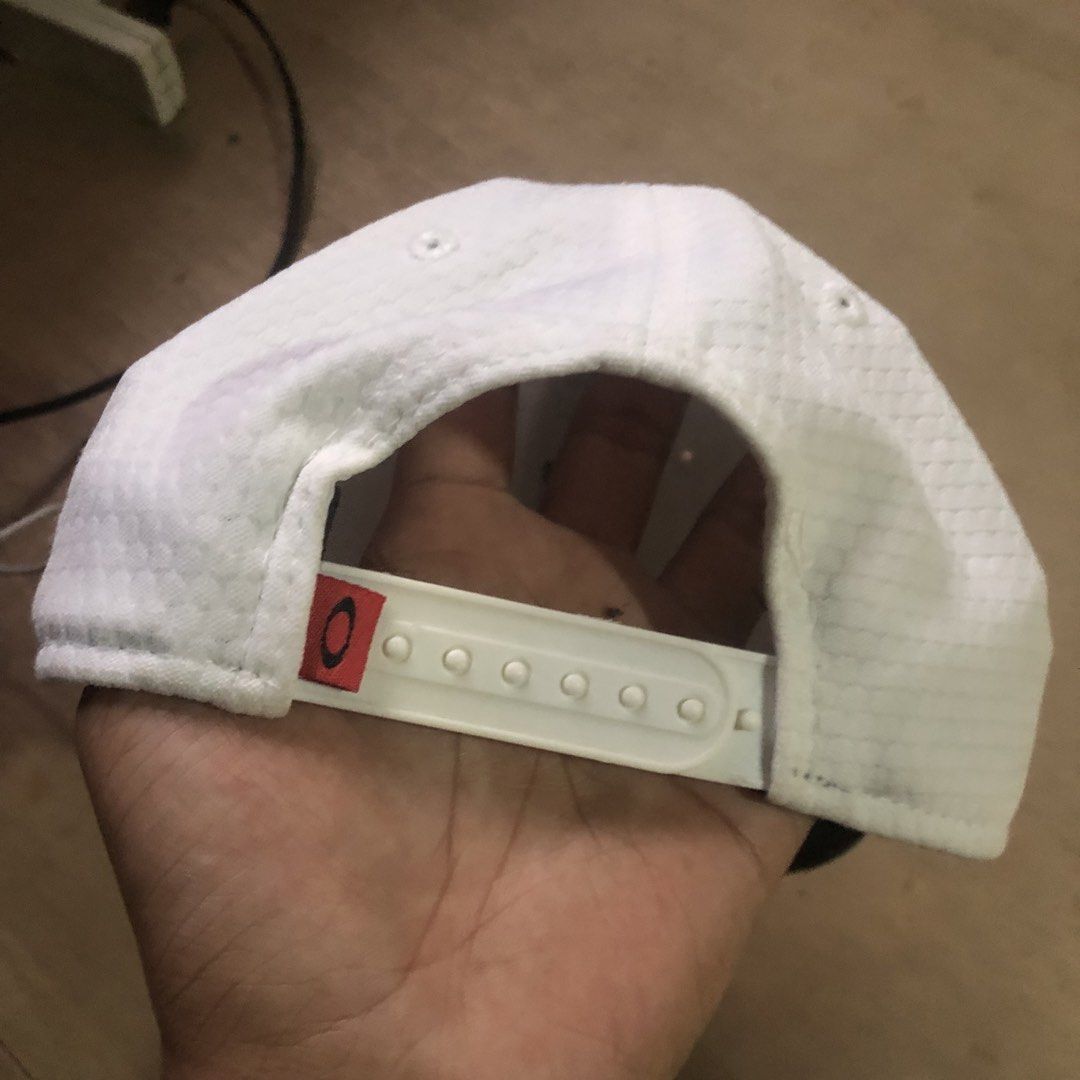 Oakley New Era Snapback Cap White (Category: Caps & Hats) located in Dasmarinas. Submitted by johnlloydm99208 (Listing ID 1452979996, Image 2). Description: - Authentic Oakley cap, perfect for everyday wear. - Features the iconic Oakley logo prominently on the front. - Includes New Era branding on the side and inside for added detail. - Adjustable snapback closure ensures a comfortable, custom fit. - Crafted with a unique textured fabric for a st
