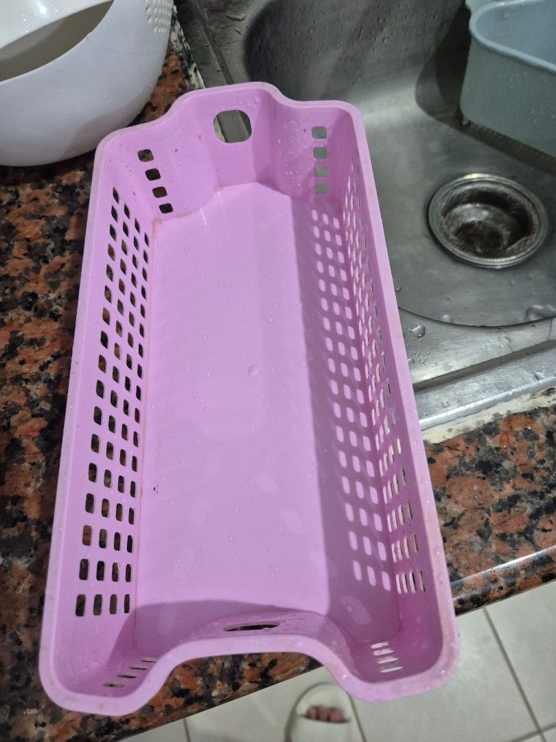 Pink Plastic Storage Basket Organizer (Category: Storage Boxes & Baskets) located in Manila. Submitted by zotag (Listing ID 1452988100, Image 1). Description: - Pink plastic storage basket - Rectangular shape with convenient cut-out handles - Grid pattern on sides and bottom for drainage/ventilation - Ideal for organizing small items in the kitchen, bathroom, or desk.