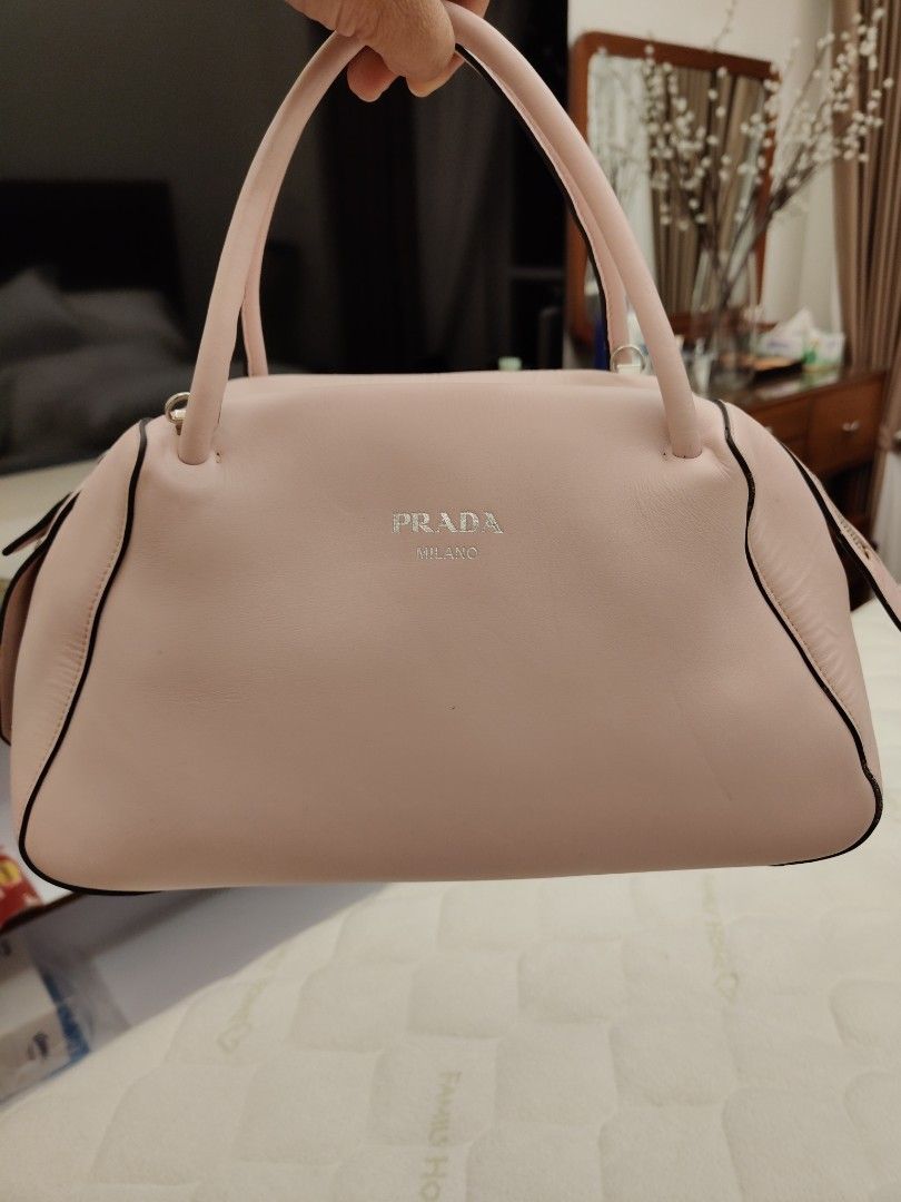 Prada Milano Pink Leather Top Handle Bag (Category: Luxury Bags & Wallets) located in Pasay City. Submitted by janiell (Listing ID 1452991179, Image 1). Description: - Authentic Prada bag - Lovely pastel pink color - Made from genuine leather - Features top handles - Includes a detachable shoulder strap - Smooth zip closure - Comes with a Prada triangle logo charm - Versatile for daily use or special occasions.