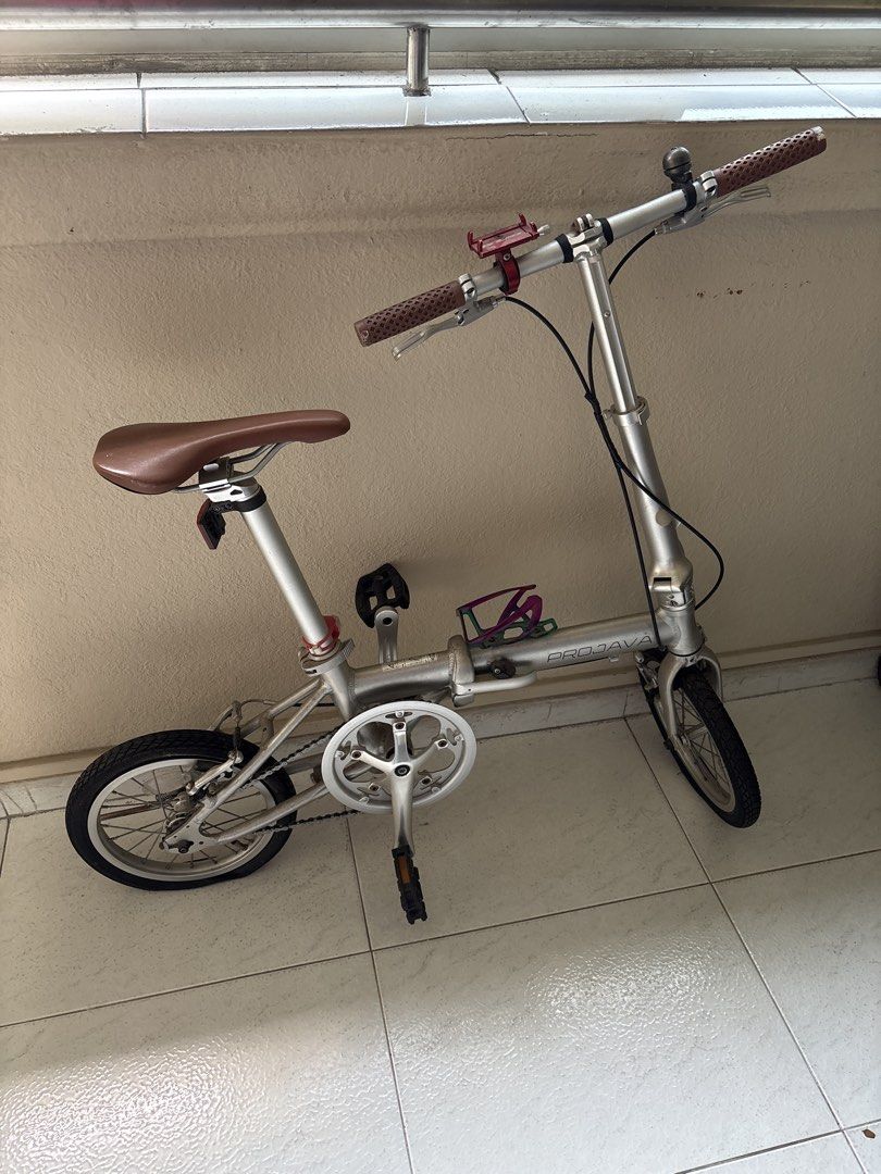 PROJAVA Folding Bicycle Silver (Category: Bicycles) located in Singapore. Submitted by debbie07js (Listing ID 1452922338, Image 1). Description: - Silver PROJAVA folding bike - Ideal for commutes and leisure rides - Brown grips and saddle - Includes phone holder and bell - Small wheels for easy folding and storage - Perfect for city cycling need to pump tyres.