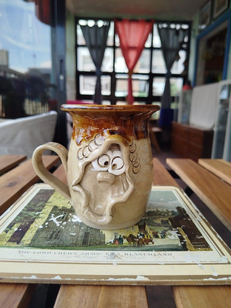 Quirky Face Ceramic Mug (Category: Coffee & Tea Tableware) located in Makati City. Submitted by meowmyella (Listing ID 1452937527, Image 1). Description: Vintage handmade "Pretty Ugly Pottery" novelty face mug from Wales featuring a characteristic peeking sculpted character with quirky protruding eyes. Kindly send DM for more details.