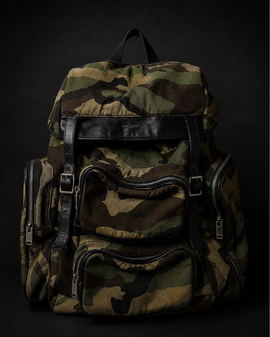 Saint Laurent Paris Camouflage Utility Backpack (Category: Luxury Bags & Wallets) located in Manila. Submitted by rarefindsph0811 (Listing ID 1453026323, Image 1). Description: 💼 Stylish military-inspired backpack featuring the iconic Saint Laurent camouflage design. Perfect for everyday use, travel, work, or as a statement luxury piece. Details: * ✅ Camouflage canvas with black leather trim * ✅ Multiple zip compartments for excellent organizati