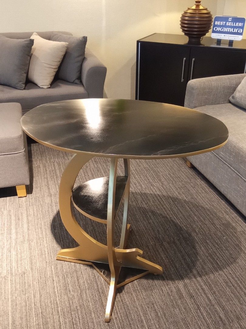 SIDE TABLE (Category: Tables & Sets) located in Valenzuela. Submitted by jesspesongco (Listing ID 1452886726, Image 1). Description: SIDE TABLE PRICE: 4,500 SIZE: W: 76cm L: 50cm. H:75cm - Dark top with striking gold curved base - Integrated small shelf for extra storage - Ideal for living rooms or as a bedside table - Adds a modern touch to any space Location: OFFICEBUSTERS Balintawak Look for Hesus / 09616904709 .