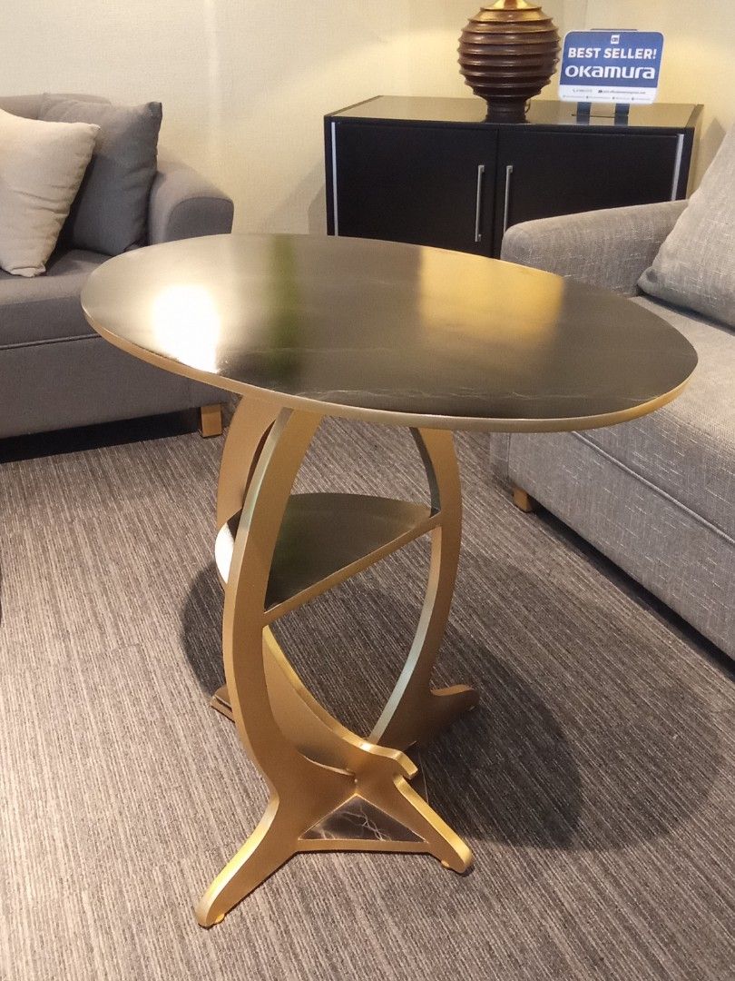 SIDE TABLE (Category: Tables & Sets) located in Valenzuela. Submitted by jesspesongco (Listing ID 1452886726, Image 3). Description: SIDE TABLE PRICE: 4,500 SIZE: W: 76cm L: 50cm. H:75cm - Dark top with striking gold curved base - Integrated small shelf for extra storage - Ideal for living rooms or as a bedside table - Adds a modern touch to any space Location: OFFICEBUSTERS Balintawak Look for Hesus / 09616904709 .