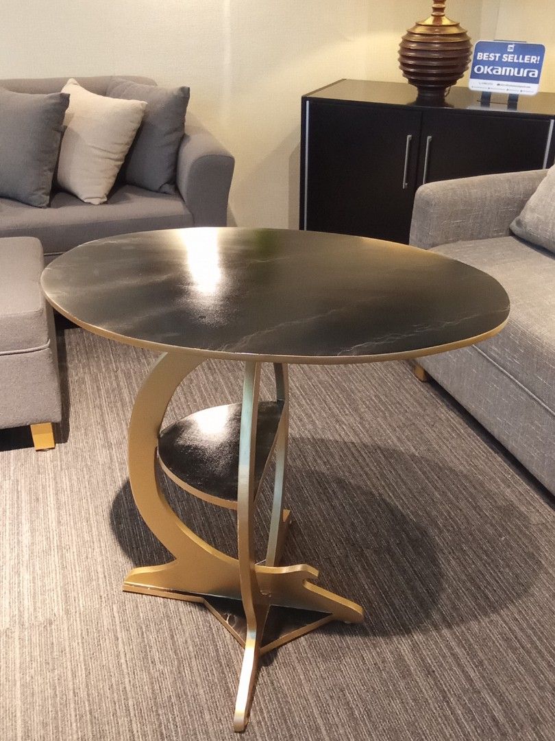 SIDE TABLE (Category: Tables & Sets) located in Valenzuela. Submitted by jesspesongco (Listing ID 1452886726, Image 2). Description: SIDE TABLE PRICE: 4,500 SIZE: W: 76cm L: 50cm. H:75cm - Dark top with striking gold curved base - Integrated small shelf for extra storage - Ideal for living rooms or as a bedside table - Adds a modern touch to any space Location: OFFICEBUSTERS Balintawak Look for Hesus / 09616904709 .