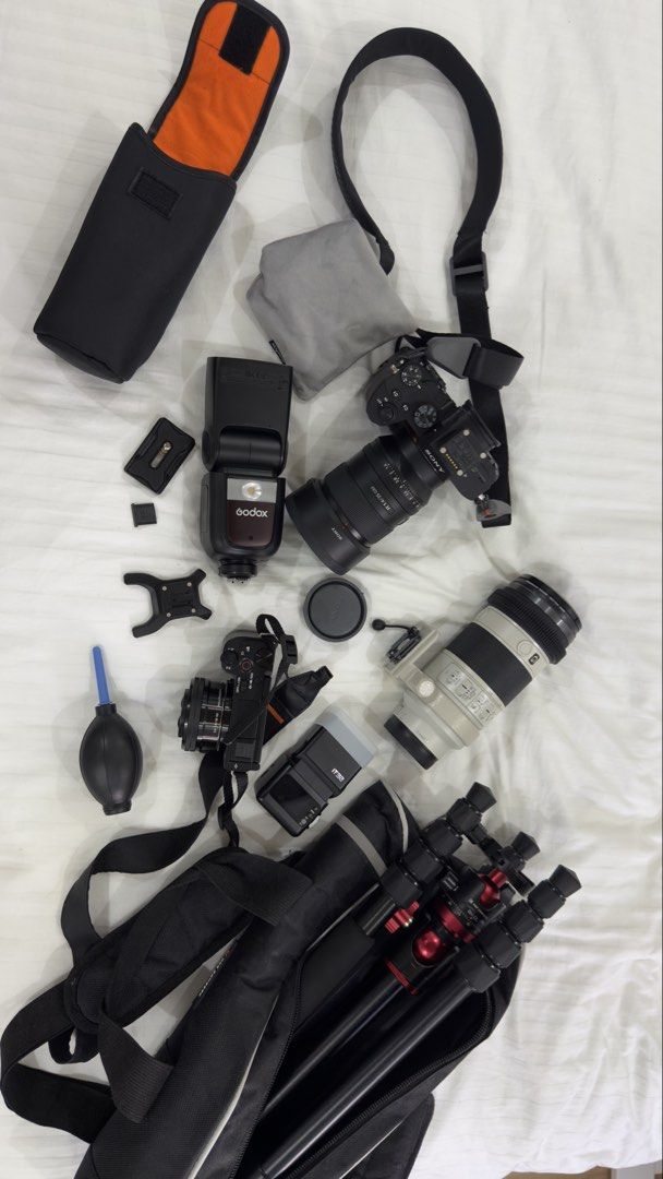Sony Camera Bundle with Lenses, Flash, Tripod, and Bag (Category: Cameras) located in Agdangan. Submitted by oqihm (Listing ID 1452911954, Image 2). Description: - 2 Sony Camera Body - 2 Sony Lenses - Godox Flash - Tripod - Carrying Bag - Ideal for photography enthusiasts - All items pictured - Message for questions Sony A7III with grip and 2 cards(64gb Sony) Complete with box Price: 60k (negotiable) Sony ZV E10 mark i with kits lens Complete wit