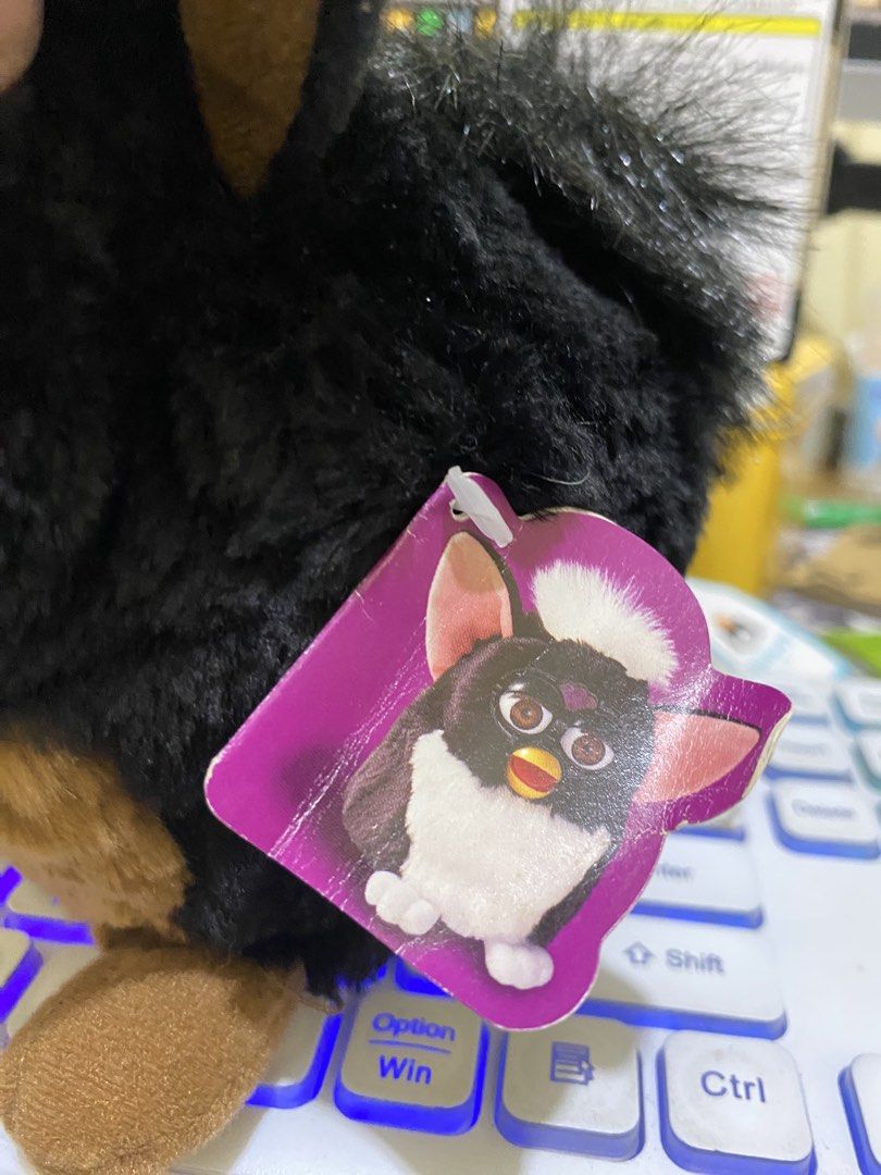 Tiger Electronics Furby Black Brown (Category: Interactive Toys) located in Imus. Submitted by mnmv23 (Listing ID 1453026892, Image 2). Description: - Vintage Furby by Tiger Electronics - Classic black and brown fur - Eyes move and beak opens - Battery compartment is clean - Includes original tag - Perfect for collectors - missing eyelash sa left eye - tested ok, sold as is.
