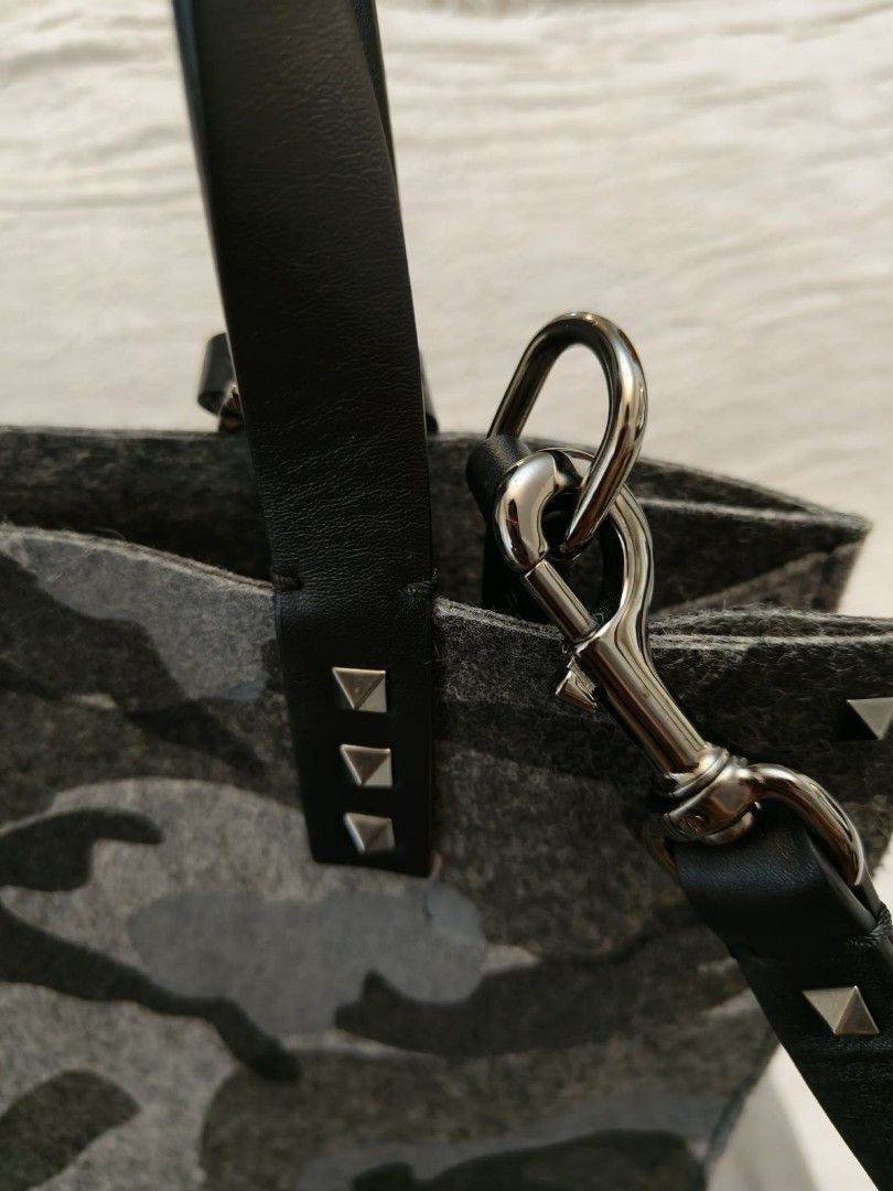 Valentino Camouflage Felt Tote Bag with Studs (Category: Luxury Bags & Wallets) located in Makati City. Submitted by iamemztot_1992 (Listing ID 1452931640, Image 3). Description: - Valentino tote bag - Grey camouflage pattern - Felt material with leather handles and trim - Signature Valentino pyramid studs - Detachable shoulder strap included - Comes with dust bag - Ideal for everyday use.