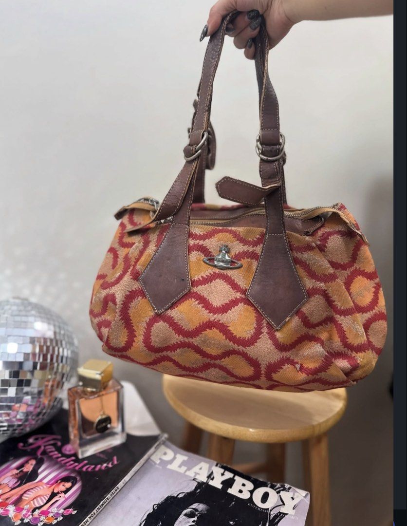 Vivienne Westwood Orb Pattern Handbag (Category: Luxury Bags & Wallets) located in Dagupan City. Submitted by shlyukha (Listing ID 1452986517, Image 1). Description: - Authentic Vivienne Westwood handbag - Features iconic orb pattern in red and orange - Genuine leather trim and handles - Secure zipper closure - Interior zip pocket for essentials - Perfect for everyday use - Shows some signs of wear on the leather, adding character.