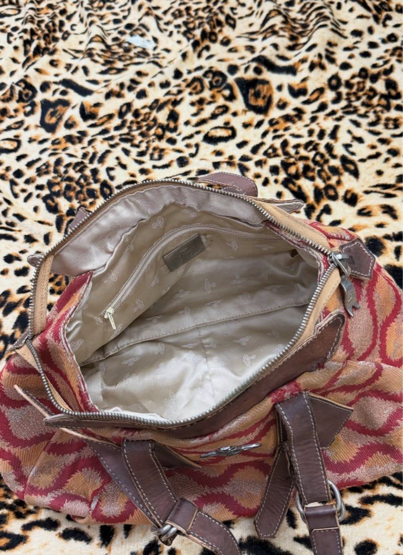Vivienne Westwood Orb Pattern Handbag (Category: Luxury Bags & Wallets) located in Dagupan City. Submitted by shlyukha (Listing ID 1452986517, Image 3). Description: - Authentic Vivienne Westwood handbag - Features iconic orb pattern in red and orange - Genuine leather trim and handles - Secure zipper closure - Interior zip pocket for essentials - Perfect for everyday use - Shows some signs of wear on the leather, adding character.