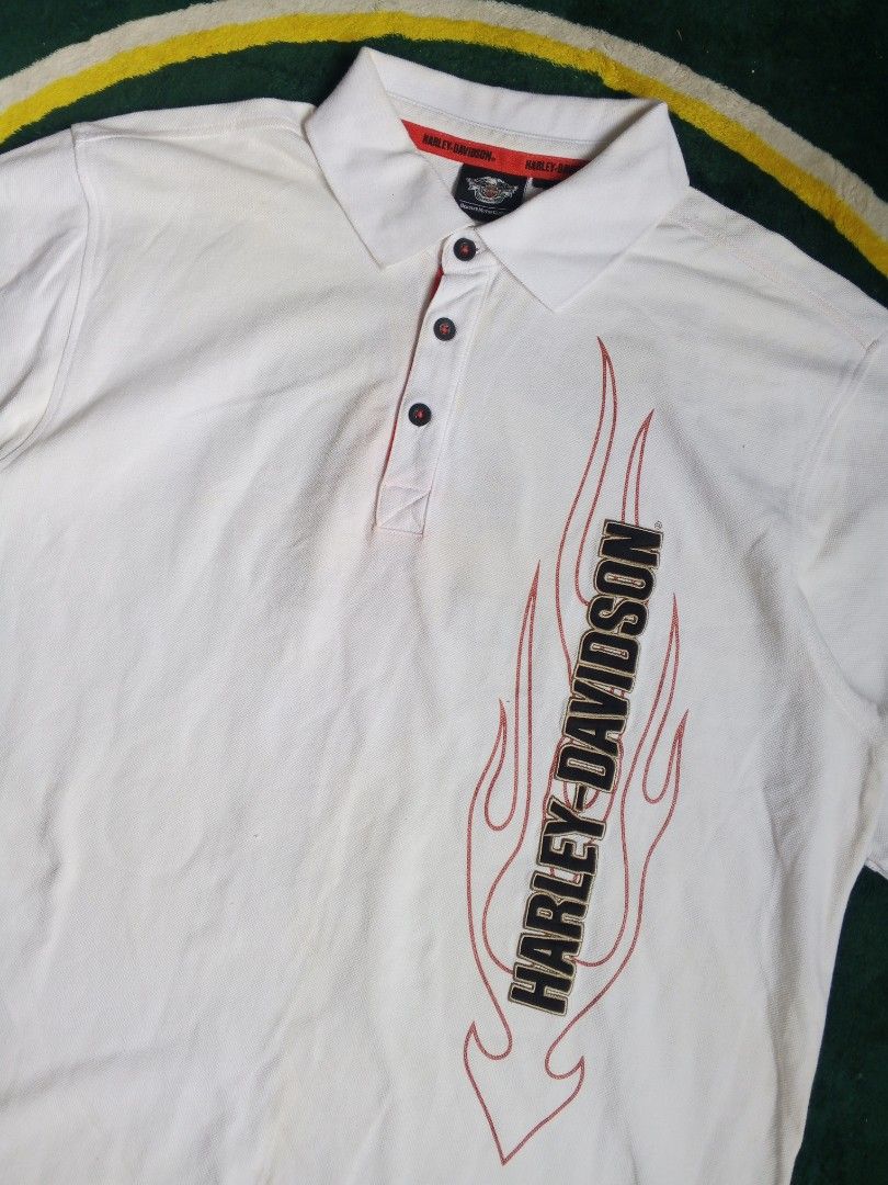 White Harley-Davidson Polo Shirt with Flame Graphics (Category: Tshirts & Polo Shirts ) located in Las Pinas. Submitted by allhandpick (Listing ID 1453019909, Image 2). Description: - White Harley-Davidson polo shirt - Features flame graphics on front and back - Classic collar with button closure - Comfortable cotton blend fabric - Ideal for any Harley-Davidson enthusiast.