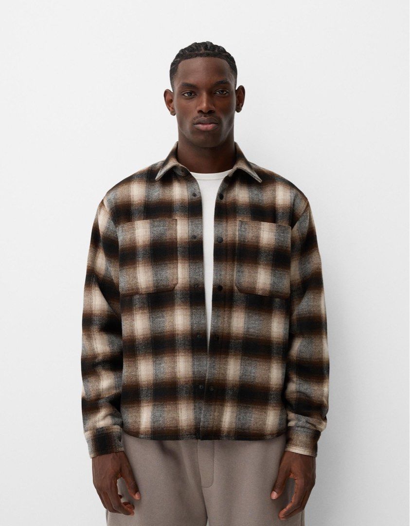 Bershka Plaid Flannel Shirt Jacket (Category: Coats, Jackets and Outerwear) located in Valenzuela. Submitted by baratoropa (Listing ID 1447580057, Image 1). Description: - Cool plaid shirt jacket from Bershka - Classic brown, black, and white checkered pattern - Feels warm and comfortable - Two chest pockets with button closures - Ideal for layering over other clothes - Perfect for everyday casual wear Original price: 2,995 pesos Selling price: 2