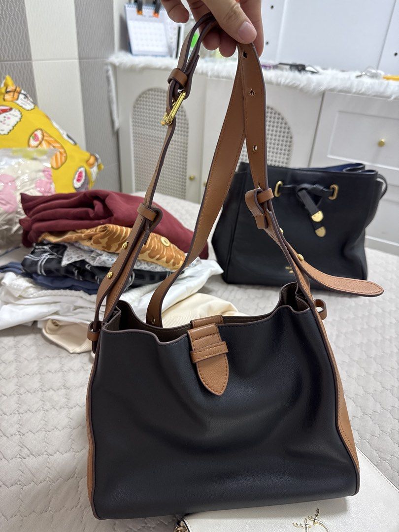 Black and Tan Leather Handbag (Category: Tote Bags) located in Santiago. Submitted by sissy.declutter (Listing ID 1447514343, Image 2). Description: - Stylish black leather handbag with elegant tan accents. - Features a secure and attractive buckle closure on the front. - Comes with an adjustable shoulder strap for comfortable carrying. - Offers a spacious interior, ideal for all your essentials. - Perfect for everyday use, blending style and pra