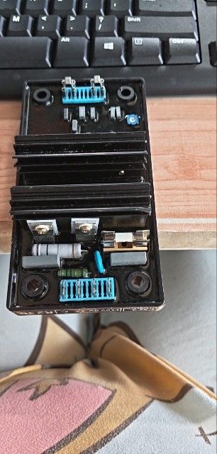 Black Voltage Regulator with Heatsink (Category: Electrical, Adaptors & Sockets) located in Pasig City. Submitted by siyerli8 (Listing ID 1447471859, Image 1). Description: - Black voltage regulator with integrated heatsink - Equipped with multiple blue connectors - Includes several resistors - Ideal for generator or similar equipment applications.