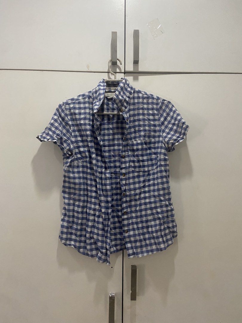 Blue and White Gingham Short Sleeve Button-Up Shirt (Category: Shirts) located in Marikina City. Submitted by scarkiv (Listing ID 1447657389, Image 1). Description: - Classic blue and white gingham pattern - Short sleeves - Button-up front - Casual fit - Ideal for everyday wear - Pairs well with jeans or shorts.