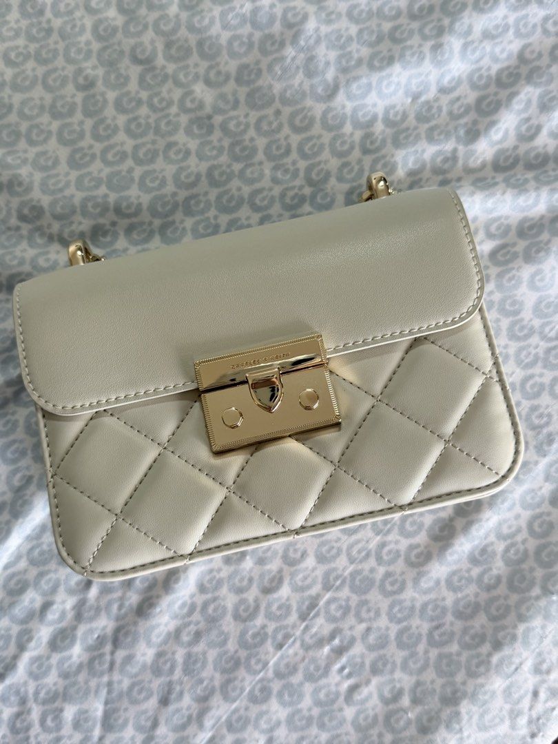 Charles & Keith Quilted Chain Shoulder Bag Cream (Category: Shoulder Bags) located in Quezon City. Submitted by fabeelousph (Listing ID 1447479142, Image 1). Description: - Cream quilted shoulder bag - Gold chain strap - Classic turn-lock closure - Compact size, ideal for essentials - Great for evening events - Clean interior - Minimal signs of wear.