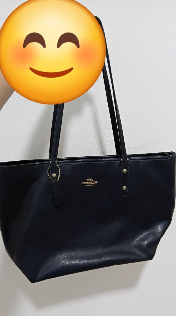 Coach Navy Leather Tote Bag (Category: Tote Bags) located in Kuching. Submitted by fyna28 (Listing ID 1447611625, Image 1). Description: - Classic navy blue Coach tote bag - Made from textured leather - Iconic Coach horse and carriage logo on front - Main compartment with zip closure - Includes Coach leather hangtag - Gold hardware details - Great for everyday use.