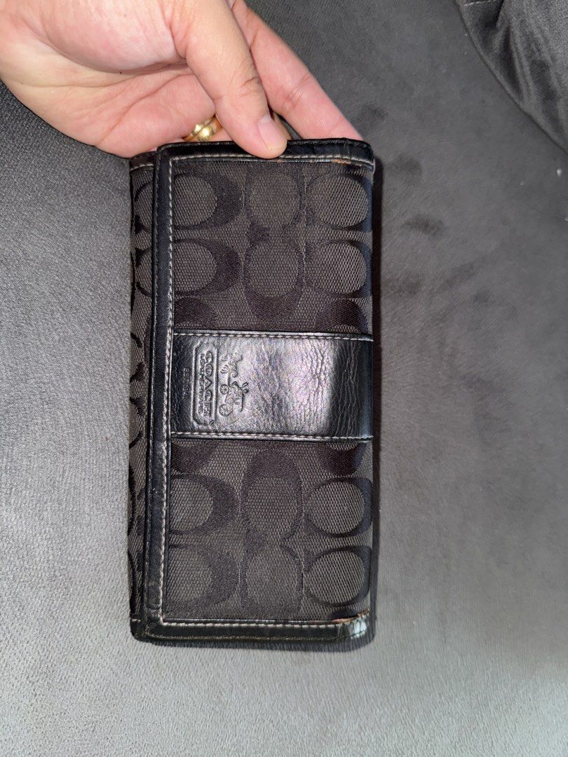 Coach Signature C Monogram Wallet (Category: Luxury Bags & Wallets) located in Himamaylan. Submitted by EsClosetCleanUp (Listing ID 1447675804, Image 1). Description: - Classic Coach wallet with signature C monogram pattern. - Color: Black fabric with black leather trim. - Interior: Multiple card slots and a zippered coin pocket. - Closure: Secure snap closure. - Condition: Shows some signs of wear on edges and interior, but plenty of life left. 