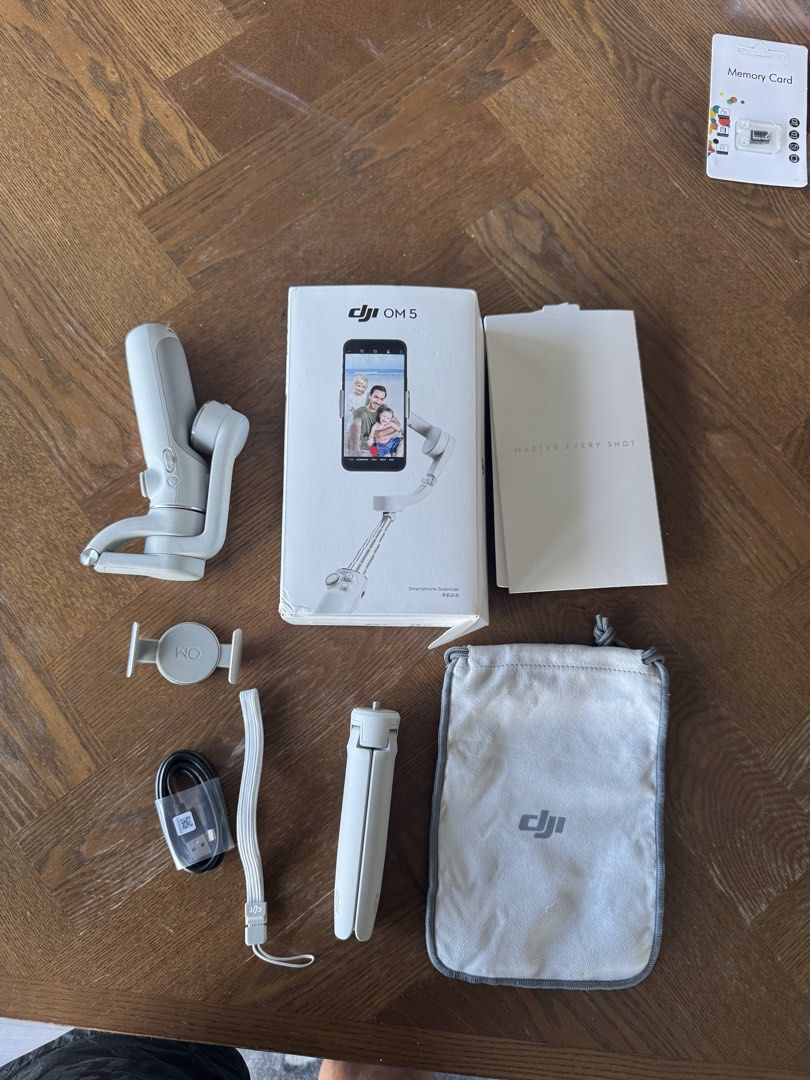 DJI Om 5 Gimbal Stabilizer (Category: Camera Bags & Carriers) located in Manila. Submitted by handoverfist (Listing ID 1447544748, Image 3). Description: This is a DJI OM 5 smartphone stabilizer, specifically the gray variant as shown on the box.The device features 3-axis stabilization and includes a built-in extension rod for selfies or higher-angle shots.It utilizes a magnetic clamp system to easily attach and detach your mobile phone..