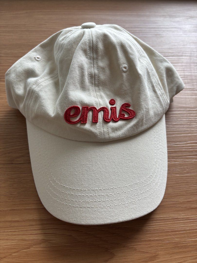 Emis Cap (Category: Caps & Hats) located in Singapore. Submitted by decluttertime17 (Listing ID 1447489293, Image 1). Description: - Brand: Emis - Type: Cap - Color: Cream/Beige - Logo: Red embroidered 'emis' - Condition: Excellent, like new - Style: Casual, versatile.