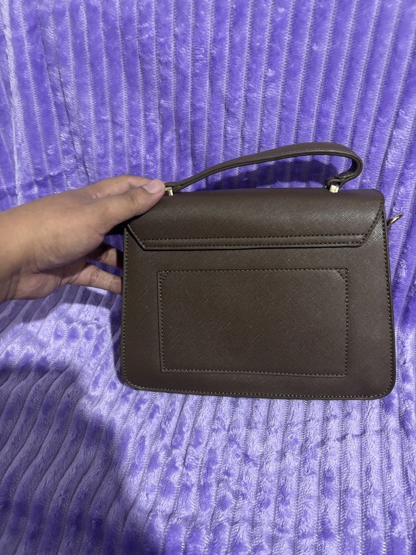 Esquire Brown Handbag with Orange Strap (Category: Luxury Bags & Wallets) located in Manila. Submitted by thecalvinedit (Listing ID 1410923900, Image 3). Description: Brown handbag with a top handle and a detachable orange strap. The bag has a flap closure and a small brand logo on the front. The strap has gold-colored hardware. It has a structured shape..