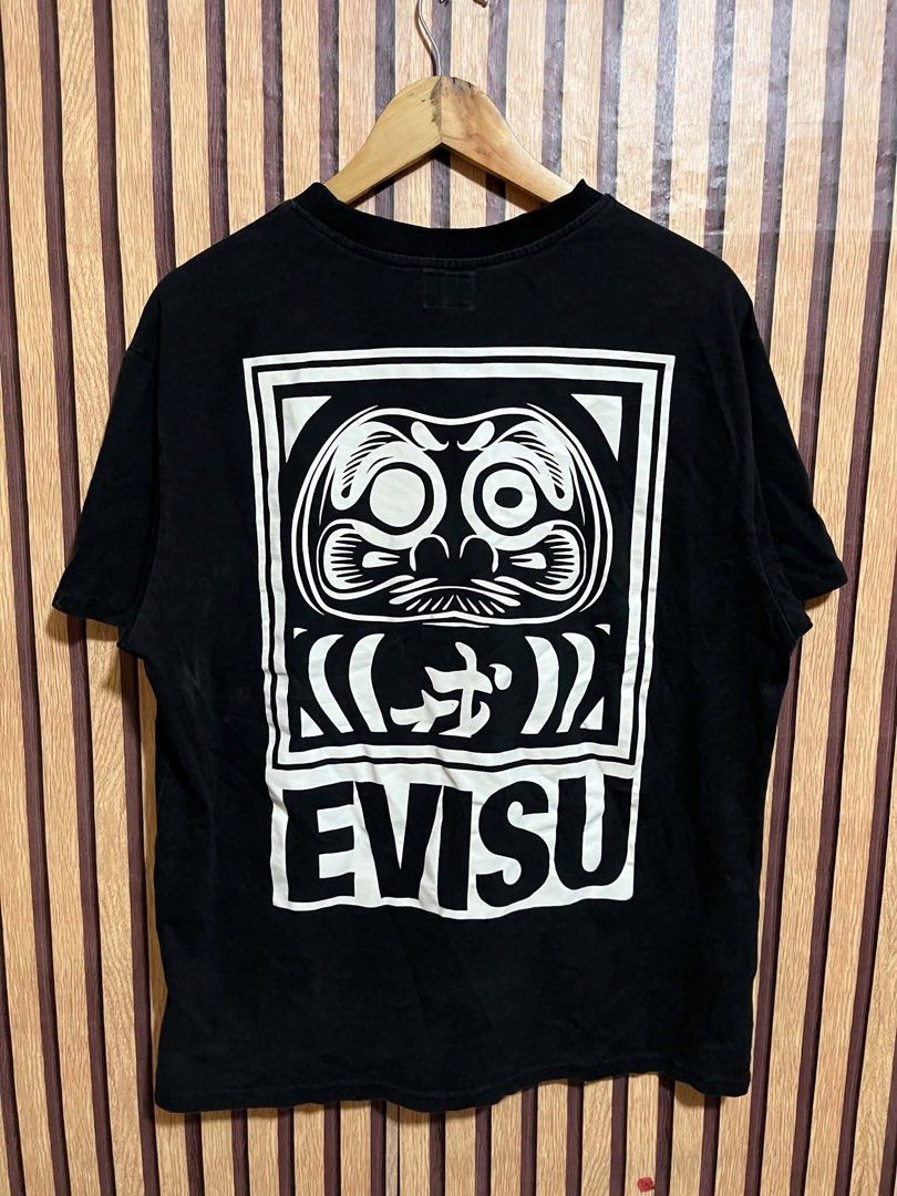EVISU T-shirt Black Daruma Graphic Tee (Category: Tshirts & Polo Shirts ) located in Santiago. Submitted by bakithrift (Listing ID 1447598295, Image 2). Description: - Black Evisu T-shirt - Features iconic Daruma graphic on the back - Smaller graphic detail on the front - Short sleeves - Crew neck - Ideal for casual outfits.