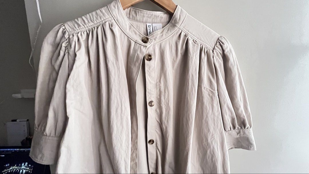 H&M Divided Beige Cropped Puff Sleeve Blouse (Category: Blouses) located in Manila. Submitted by mightystone_eb209a (Listing ID 1447490729, Image 2). Description: - Cute beige cropped blouse from H&M Divided - Features stylish puff sleeves - Button-up front for a customizable fit - Chic Mandarin collar - Lightweight fabric, ideal for warm weather - Versatile for casual or dressy looks - Pairs perfectly with high-waisted bottoms.