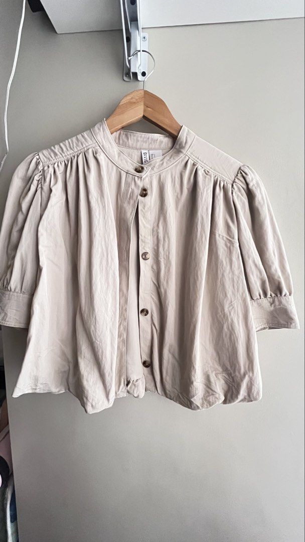 H&M Divided Beige Cropped Puff Sleeve Blouse (Category: Blouses) located in Manila. Submitted by mightystone_eb209a (Listing ID 1447490729, Image 1). Description: - Cute beige cropped blouse from H&M Divided - Features stylish puff sleeves - Button-up front for a customizable fit - Chic Mandarin collar - Lightweight fabric, ideal for warm weather - Versatile for casual or dressy looks - Pairs perfectly with high-waisted bottoms.
