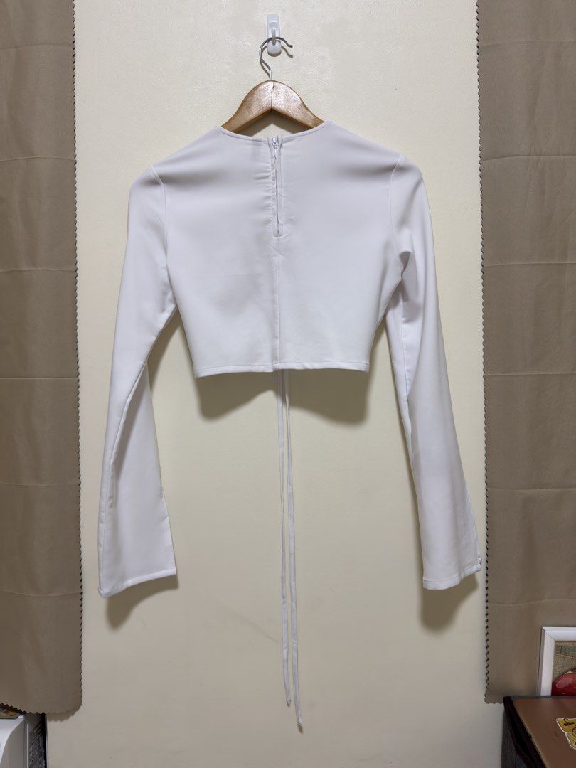 H&M White Ruched Long Sleeve Crop Top (Category: Longsleeves) located in Manila. Submitted by seayouncey (Listing ID 1447656767, Image 2). Description: - Brand: H&M - Style: Long sleeve crop top - Color: White - Features: Ruched front with drawstring, bell sleeves - Closure: Zipper at the back - Versatile: Perfect for dressing up or down.