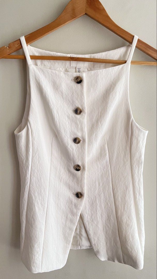 H&M White Sleeveless Button-Up Top Size US 4 (Category: Sleeveless) located in Manila. Submitted by mightystone_eb209a (Listing ID 1447492196, Image 1). Description: - White sleeveless top from H&M - Features a square neckline and button-up front - Comfortable textured fabric - Perfect for layering or wearing on its own - Effortlessly stylish for various occasions - Refer to the tag for specific sizing information.