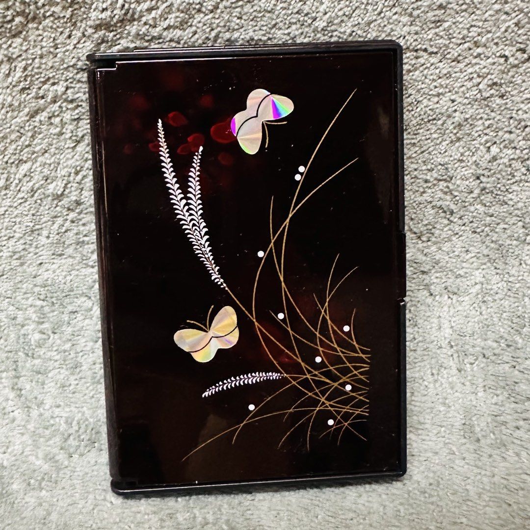 Lacquerware Mirror / Tissue Holder (Category: Other Accessories) located in Manila. Submitted by rarefindsgallery (Listing ID 1447567428, Image 1). Description: Lacquerware Mirror and Tissue Holder Size : 4” x 2.8” Very cute in actual Mirror na lagayan ng tissue Made in Japan 🇯🇵 This is a vintage-style address book featuring a black lacquerware finish.The cover is decorated with iridescent butterfly and grass motifs, likely using a shell inlay 