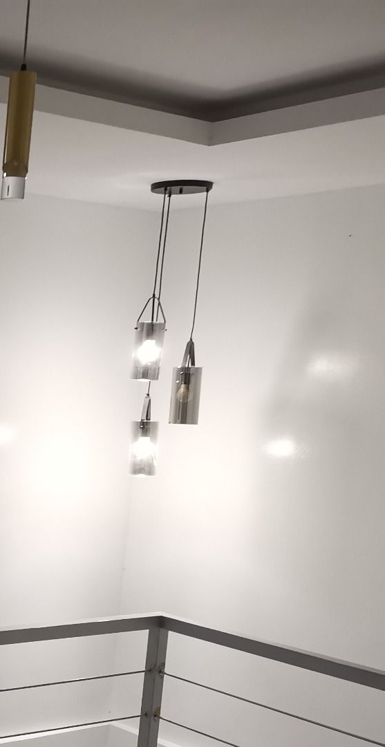 Modern 3-Light Pendant Chandelier (Category: Lighting) located in Orani. Submitted by pure_jim_m (Listing ID 1447516292, Image 1). Description: - Stylish modern pendant light - Features three cylindrical glass shades - Shades have a smoky grey tint - Hangs from a black circular ceiling mount - Bulbs are visible inside the shades - Ideal for dining areas, living rooms, or entryways - Adds a contemporary feel to any space.