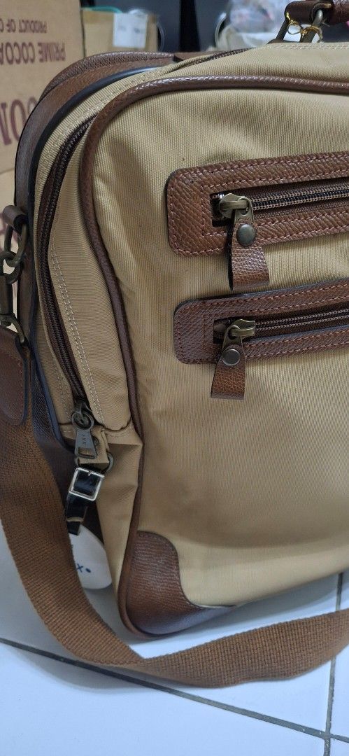 Murdock Tan Canvas Leather Trim Messenger Bag (Category: Sling Bags) located in Manila. Submitted by youngcloud_b1fffa (Listing ID 1447657590, Image 3). Description: - Tan Murdock messenger bag - Brown leather accents - Multiple zippered compartments on the front - Top handle and adjustable shoulder strap - Spacious interior with a divider - Ideal for work or travel - Good size for essentials "R&B Mix Japan Surplus Items".