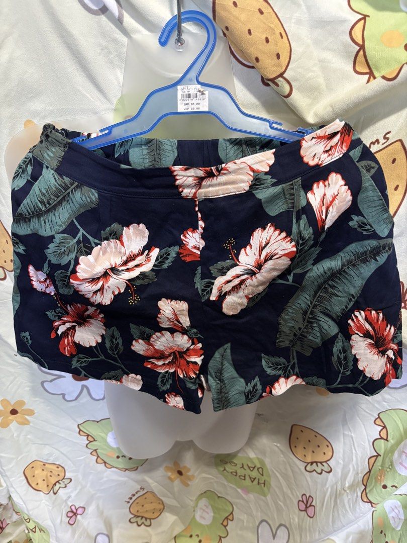 Navy Floral Print Shorts (Category: Shorts) located in Orani. Submitted by cathsclothing (Listing ID 1447499956, Image 2). Description: Size: 25”-26” (waist strechable) Length 12.5” - Garterized at the back - 2 side pocket - side zipper - Navy shorts with a bold floral and leaf print - High-waisted design - Comfortable elastic waistband - Functional front pockets - Ideal for casual outings or beach vacations - Versatile and easy to style with sim