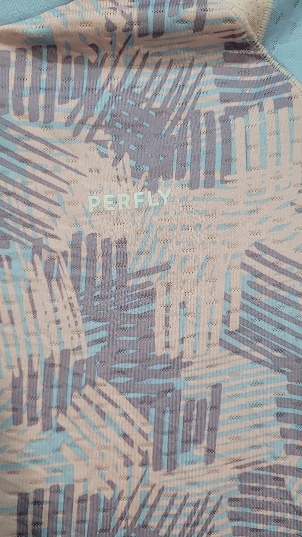 PERFLY Decathlon Kids Junior T-shirt (Category: Babies & Kids Fashion) located in Davao. Submitted by NearlyNew (Listing ID 1447589778, Image 2). Description: - Lightweight and breathable kids t-shirt from Decathlon - Features a cool abstract geometric print in pink, blue, and grey - Mesh-like texture for excellent ventilation - Ideal for sports activities or everyday casual wear - Tag indicates Junior size: 12-13 years.